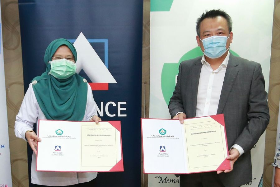 Puan Parihah Hasan, Acting Director General of Yayasan Pembangunan Ekonomi Islam Malaysia (YaPEIM) exchanges documents with Encik Zulfikar Hashman Jamalkhir, Senior Vice President, Business &amp; Market Coverage of Alliance Islamic Bank, at the Memorandum of Understanding Exchange ceremony today, inking a strategic collaboration to help small-and-medium enterprises (SMEs) and the B40 communities-in-need.