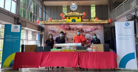 Mr. Yoshiaki Okabe (second from the left), Deputy Chief Executive Officer of Tokio Marine Life Insurance Malaysia Bhd. hands over donated items to Rev. Hemaloka (second from the right), Assistant to Founder of Ti-Ratana Welfare Society.