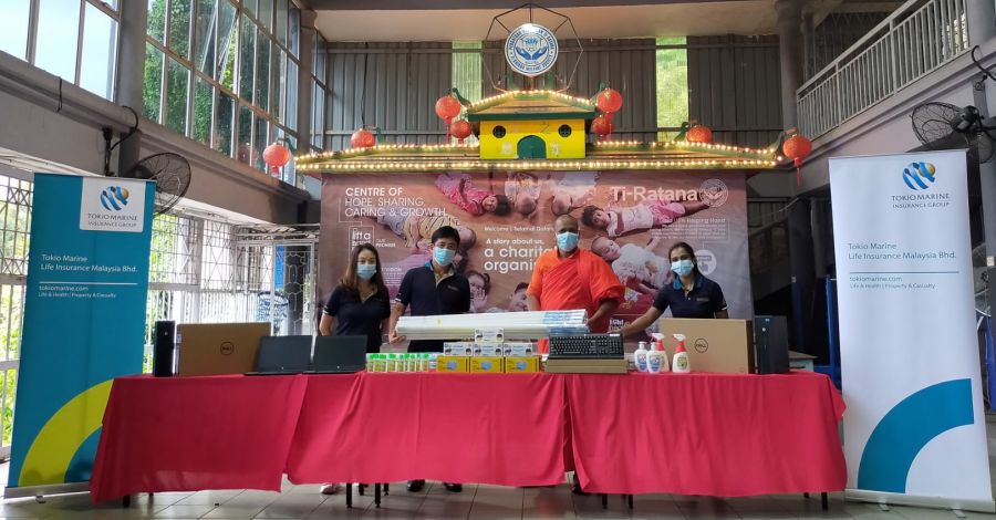 Mr. Yoshiaki Okabe (second from the left), Deputy Chief Executive Officer of Tokio Marine Life Insurance Malaysia Bhd. hands over donated items to Rev. Hemaloka (second from the right), Assistant to Founder of Ti-Ratana Welfare Society.